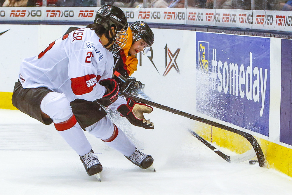 January 03 2015: Jonas Siegenthaler (25) of Switzerland fights for the puck against Germany during Switzerland's 5-2 victory over Germany at the IIHF World Junior Championship at Air Canada Centre in Toronto, Canada.