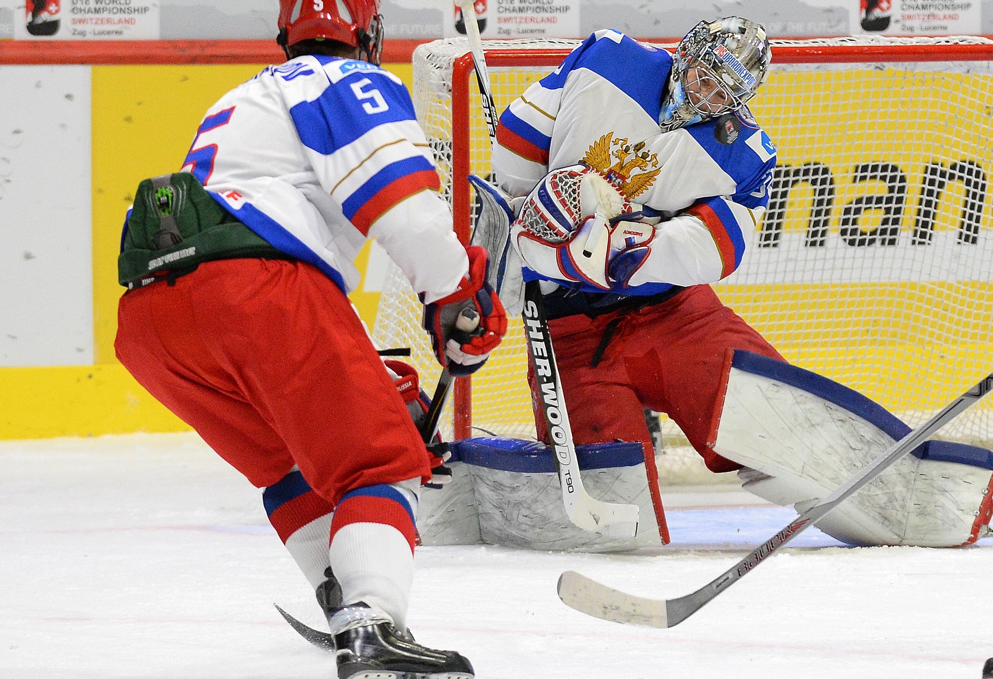 LUCERNE, SWITZERLAND - APRIL 16: Russia's Ilya Samsonov #30 makes the save against USA's Auston Matthews #19 while Mikhail Sergachyov #5 and Kirill Belyayev #28 look on during preliminary round action at the 2015 IIHF Ice Hockey U18 World Championship. (Photo by Matt Zambonin/HHOF-IIHF Images)