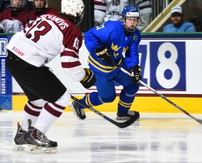 GRAND FORKS, NORTH DAKOTA - APRIL 15: Sweden's Elias Pettersson #21 skates with the puck while LatviaÕs Vlads Vulkanovs #13 defends during preliminary round action at the 2016 IIHF Ice Hockey U18 World Championship. (Photo by Matt Zambonin/HHOF-IIHF Images)
