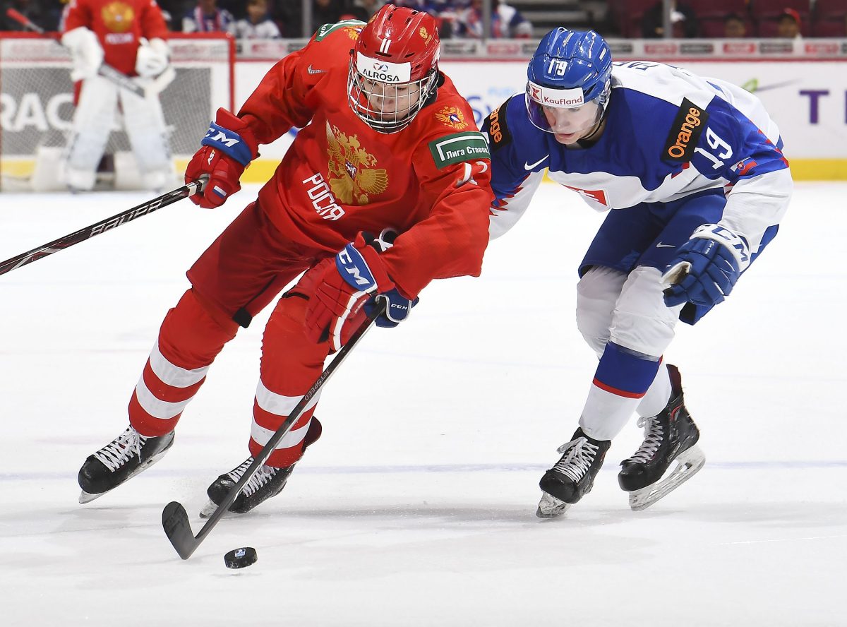 VANCOUVER, BC - JANUARY 2: Russia's Vasili Podkolzin #11 skates with the puck while fending-off Slovakia's Milos Fafrak #19 during quarterfinal round action at the 2019 IIHF World Junior Championship at Rogers Arena on January 2, 2019 in Vancouver, BC Canada. (Photo by Matt Zambonin/HHOF-IIHF Images)