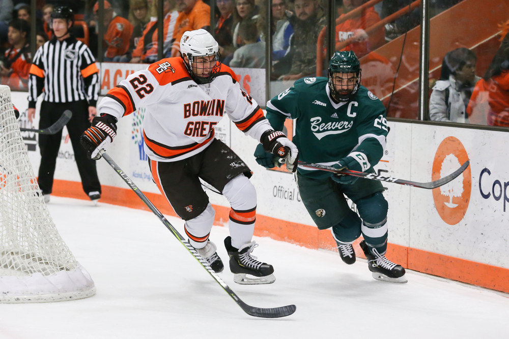 BOWLING GREEN, OH - JANUARY 03: Bowling Green Falcons forward Lukas Craggs (22) and Bemidji State Beavers defenseman Justin Baudry (29) chase after the puck during a regular season WCHA conference hockey game between the Bemidji State Beavers and the Bowling Green Falcons (12) on January 3, 2019 at the Slater Family Ice Arena in Bowling Green, Ohio. (Photo by Scott W. Grau/Icon Sportswire)