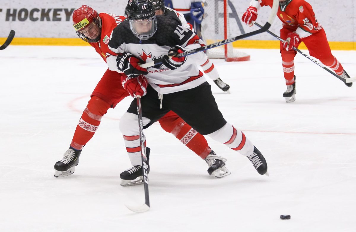 UMEA, SWEDEN - APRIL 21: Canada's Jamieson Rees #14 fends off Belarus' Sergei Kuznetsov #22 during the preliminary round of the 2019 IIHF Ice Hockey U18 World Championship at A3 Arena on April 21, 2019 in Umea, Sweden. (Photo by Chris Tanouye/HHOF-IIHF Images)