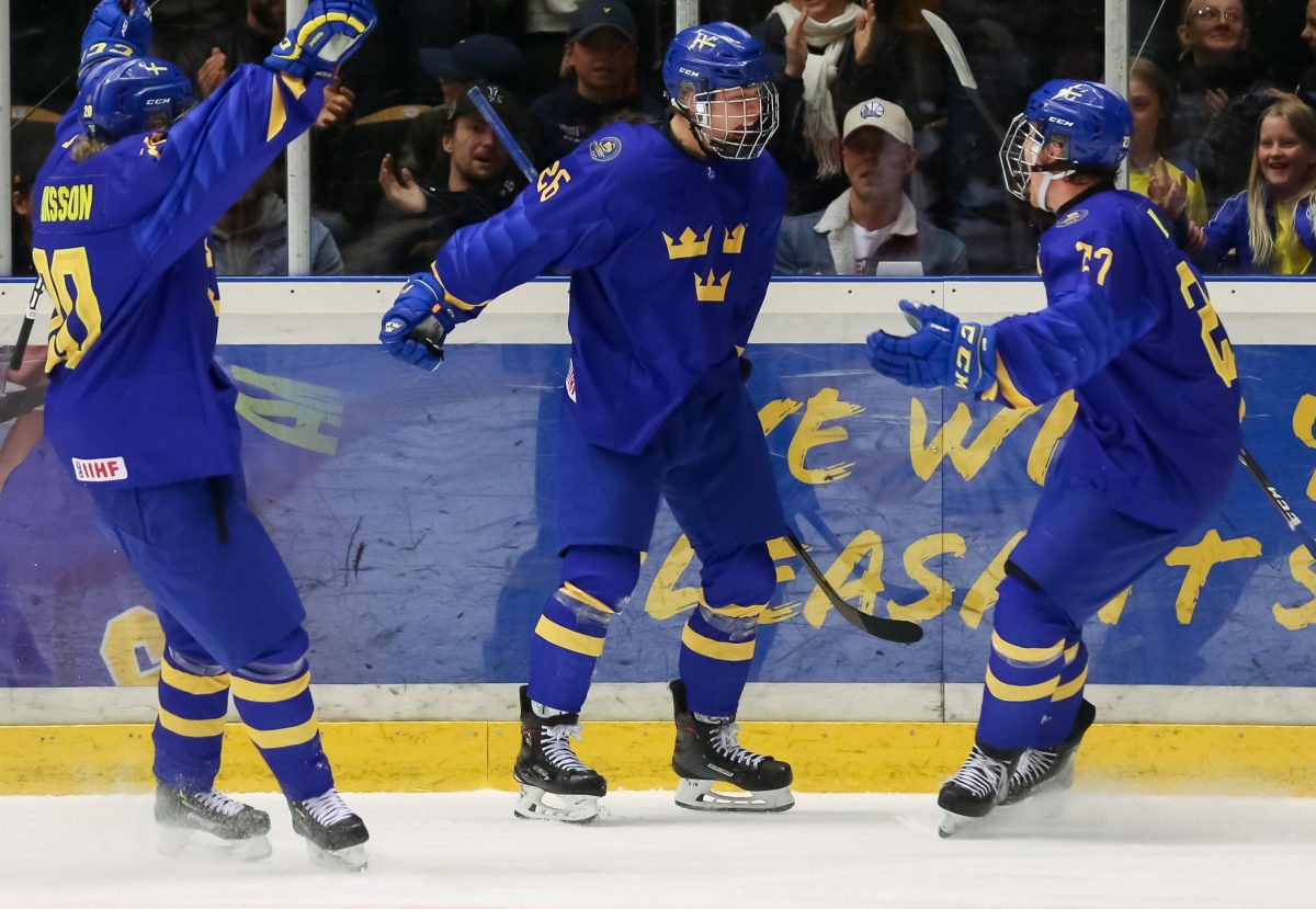 ORNSKOLDSVKIK, SWEDEN - APRIL 28: Sweden's Lucas Raymond #26 celebrates with Karl Henriksson #20 and Alexander Holtz #27 after scoring a third period goal on Team Russia during the gold medal game of the 2019 IIHF Ice Hockey U18 World Championship at Fjallraven Center on April 28, 2019 in Ornskoldsvkik, Sweden. (Photo by Chris Tanouye/HHOF-IIHF Images)