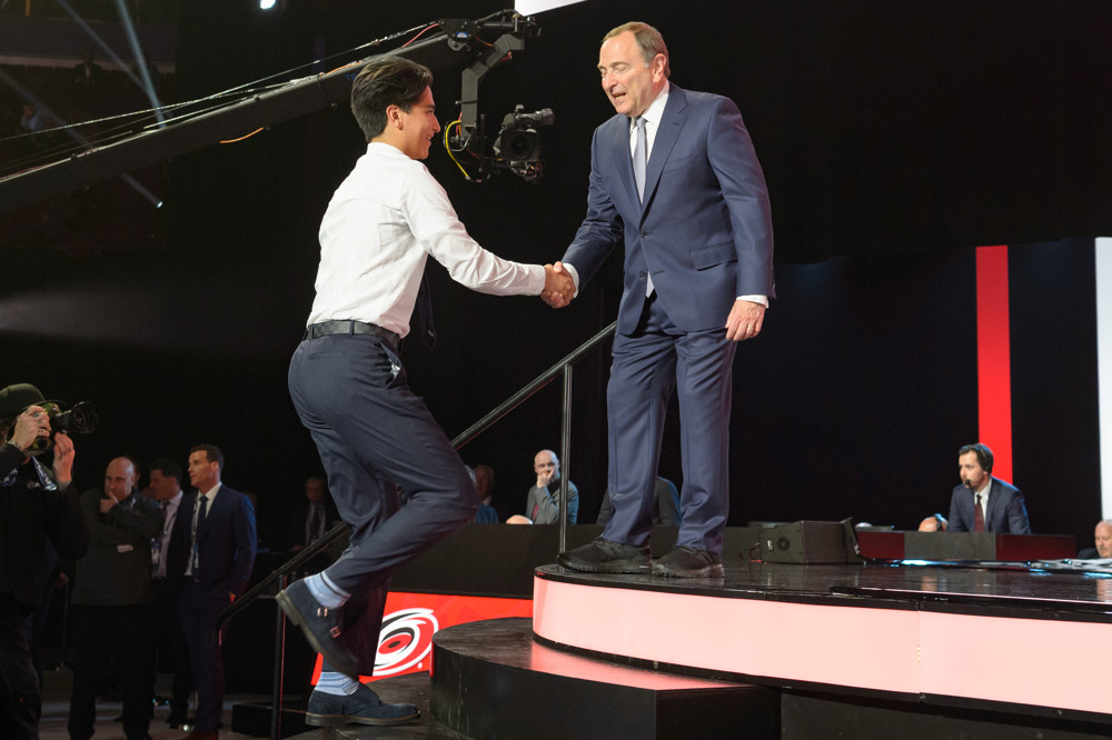 VANCOUVER, BC - JUNE 21:  Ryan Suzuki shakes hands with NHL Commissioner Gary Bettman after being picked twenty-eight overall by the Carolina Hurricanes during the first round of the 2019 NHL Draft at Rogers Arena on June 21, 2019 in Vancouver, British Columbia, Canada. (Photo by Derek Cain/Icon Sportswire)