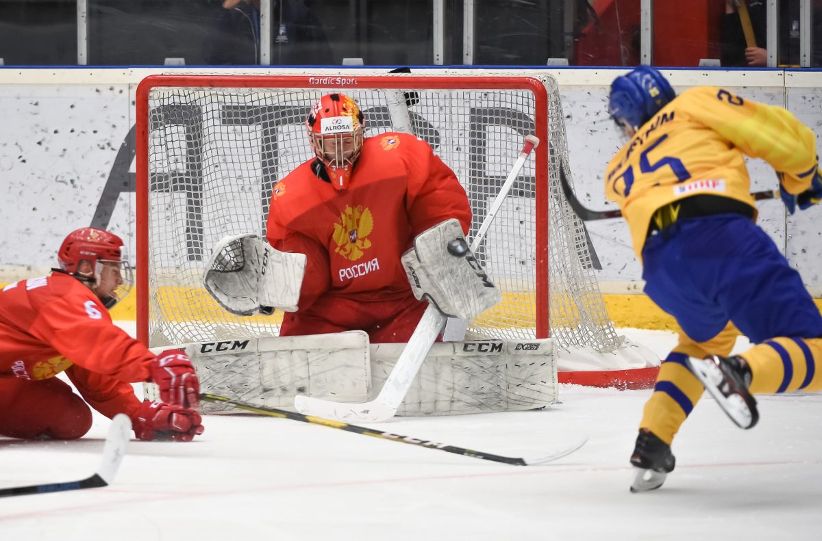 ORNSKOLDSVIK, SWEDEN - APRIL 23: Russia’s Yaroslav Askarov #1 attempts to make a blocker save against Sweden’s Simon Holmstrom #25 while Semyon Chistyakov #6 defends during preliminary round action at the 2019 IIHF Ice Hockey U18 World Championship at Fjallraven Center on April 23, 2019 in Ornskoldsvik, Sweden. (Photo by Steve Kingsman/HHOF-IIHF Images)