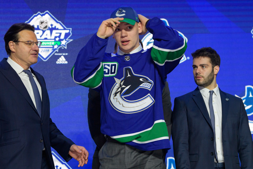 VANCOUVER, BC - JUNE 21:  Vasily Podkolzin puts on a hat after being selected tenth overall by the Vancouver Canucks during the first round of the 2019 NHL Draft at Rogers Arena on June 21, 2019 in Vancouver, British Columbia, Canada. (Photo by Derek Cain/Icon Sportswire)