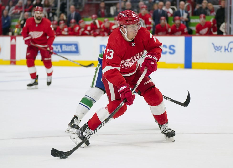 Detroit Red Wings defenseman Moritz Seider (53) defends Boston Bruins left  wing Brad Marchand (63) in